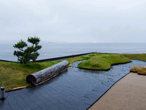 Roof garden with lawn, tree trunk, small pine tree and subtle illumination at dawn